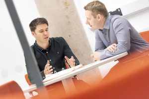 Two People Talking In Office